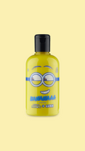 A classic LUSH shower gel bottle made with clear plastic. The bright yellow shower cream is visible through the bottle and there is a mischievous Minion face printed on the front.